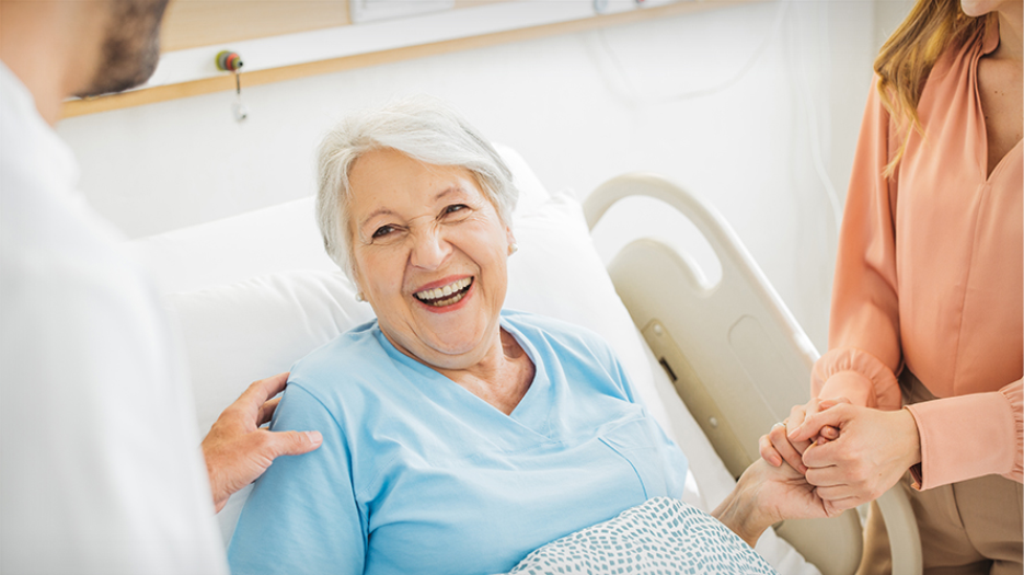 Smiling elderly woman in hospital bed